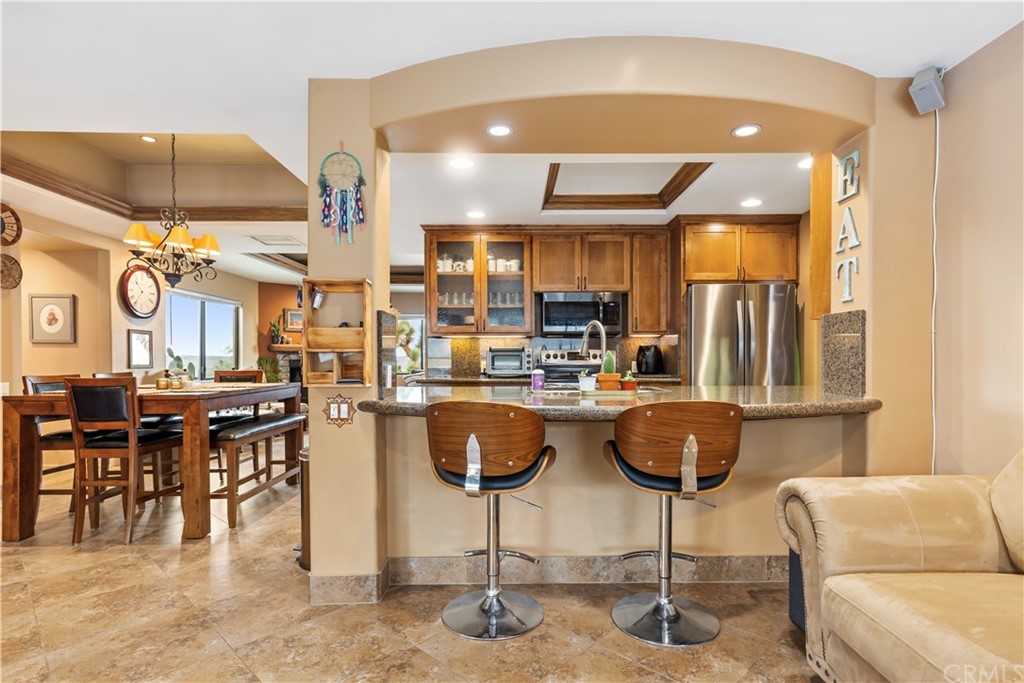 60467 Natoma Trail Joshua Tree, CA 92252 - Photo 15 of 63 a kitchen with stainless steel appliances kitchen island granite countertop a table and chairs