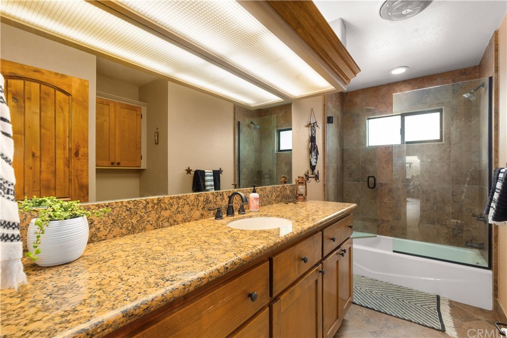 60467 Natoma Trail Joshua Tree, CA 92252 - Photo 27 of 63 a bathroom with a granite countertop sink and a mirror