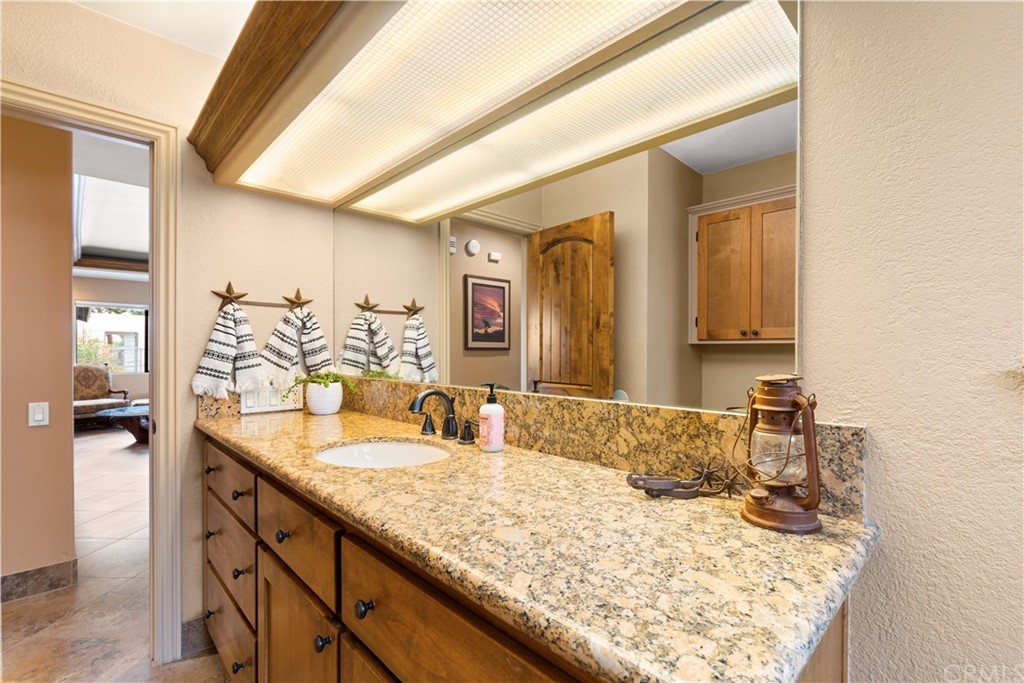 60467 Natoma Trail Joshua Tree, CA 92252 - Photo 28 of 63 a bathroom with a granite countertop sink and a mirror