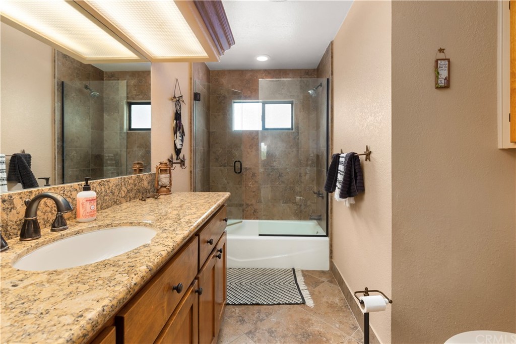 60467 Natoma Trail Joshua Tree, CA 92252 - Photo 30 of 63 a bathroom with a granite countertop sink a mirror and shower