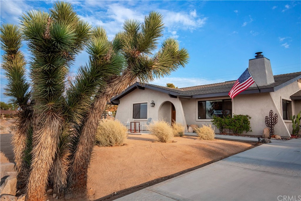 60467 Natoma Trail Joshua Tree, CA 92252 - Photo 4 of 63 a front view of a house with a yard and garage