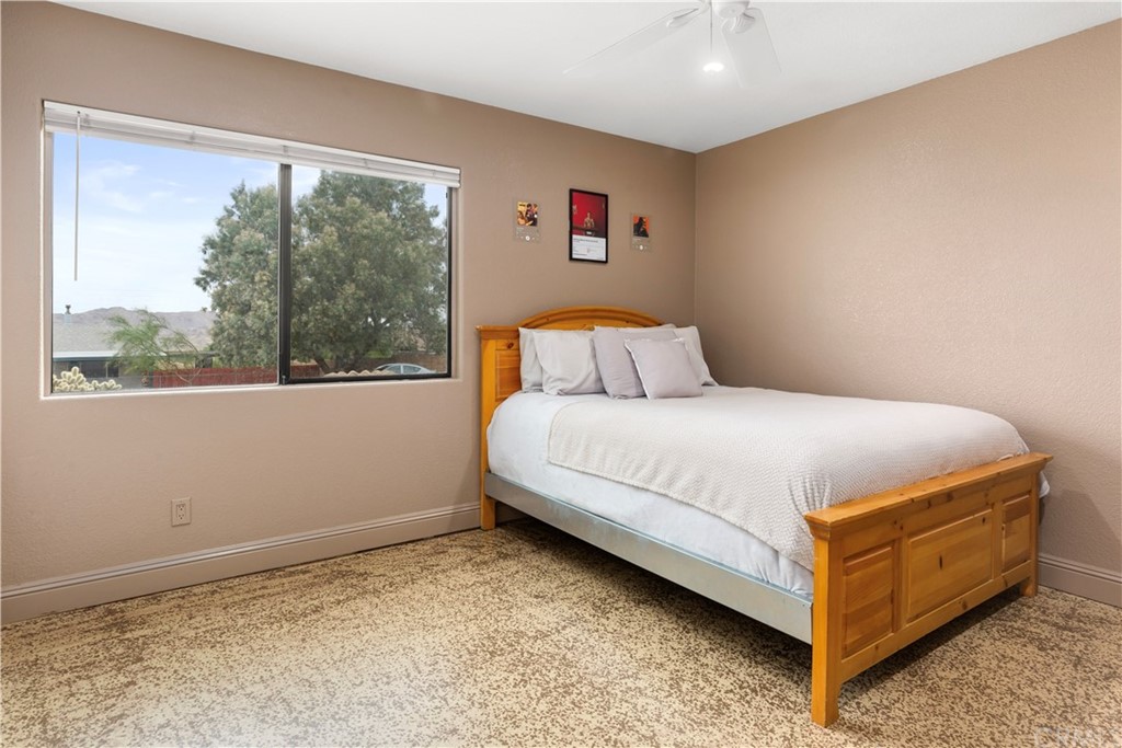 60467 Natoma Trail Joshua Tree, CA 92252 - Photo 32 of 63 a bed sitting in a bedroom next to a window