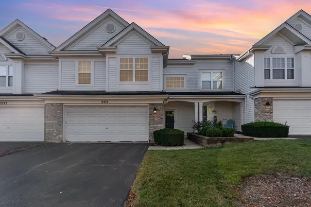 a front view of a house with a garden and plants