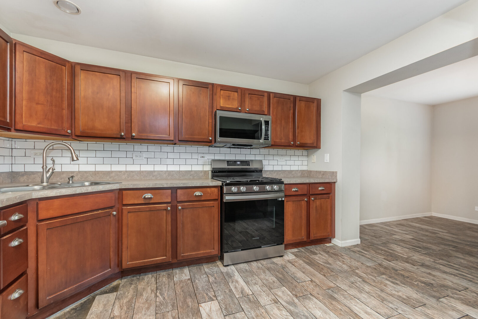 2271 Scott Lane Aurora, IL 60502 - Photo 6 of 18 a kitchen with stainless steel appliances granite countertop wooden cabinets a stove top oven a sink and dishwasher