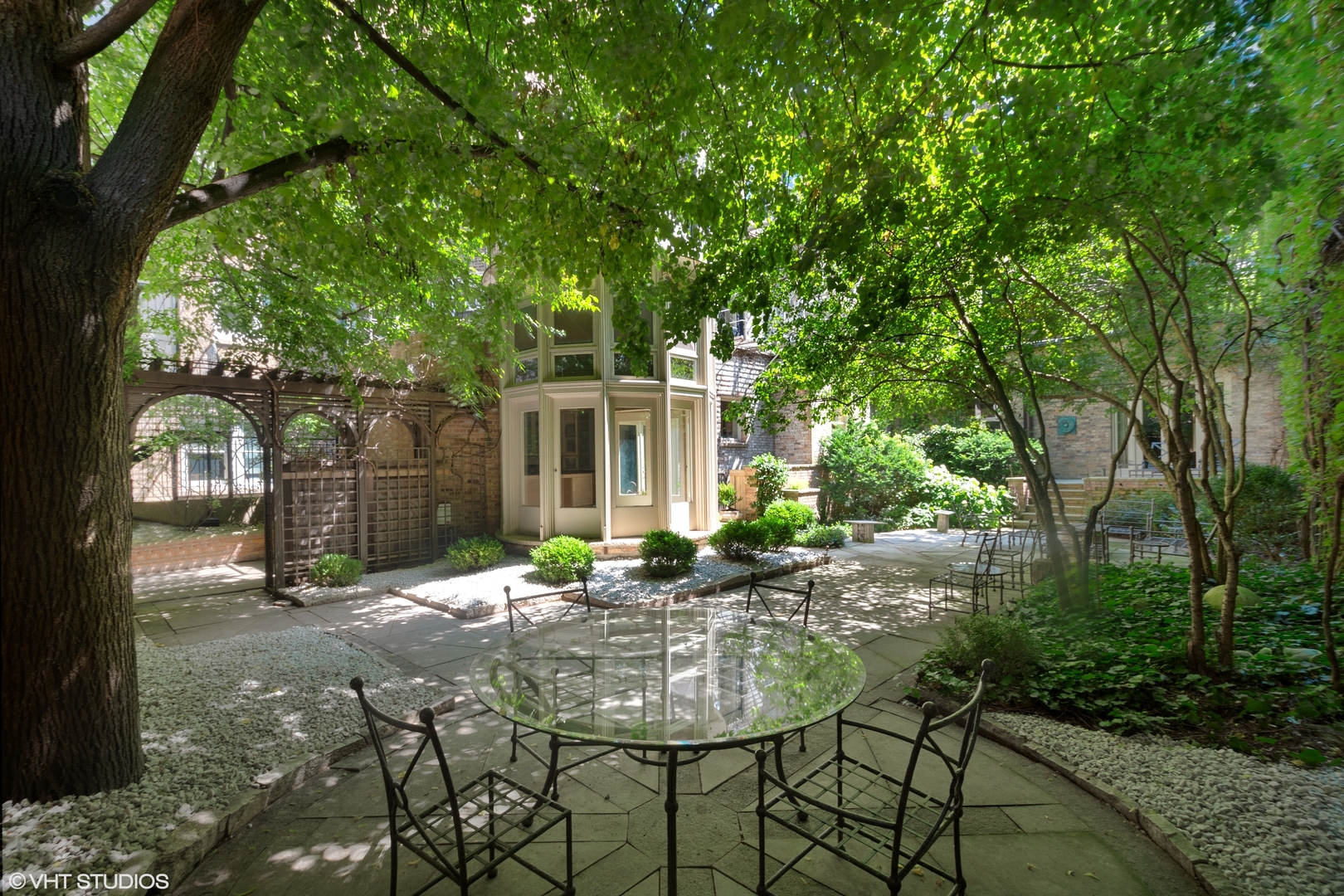 1442 North Astor Street Chicago, IL 60610 - Photo 55 of 55 a backyard of a house with table and chairs a barbeque with a large tree