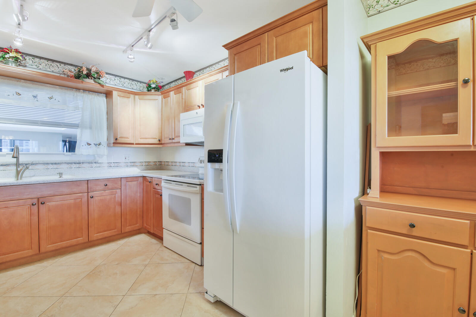 401 Briny Avenue, Unit 516 Pompano Beach, FL 33062 - Photo 12 of 38 a kitchen with a refrigerator a sink and cabinets