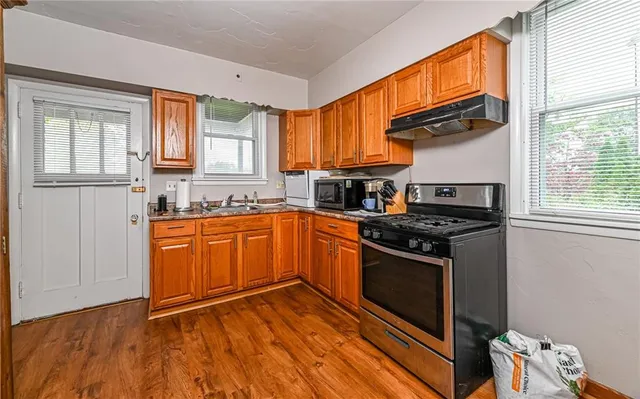a kitchen with stainless steel appliances granite countertop a stove a sink and a refrigerator