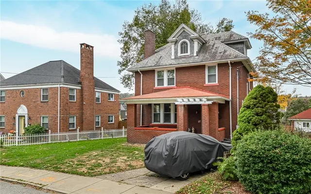 a front view of a house with a garden and plants