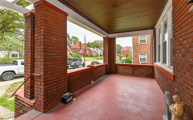 a view of a porch with wooden floor and iron stairs