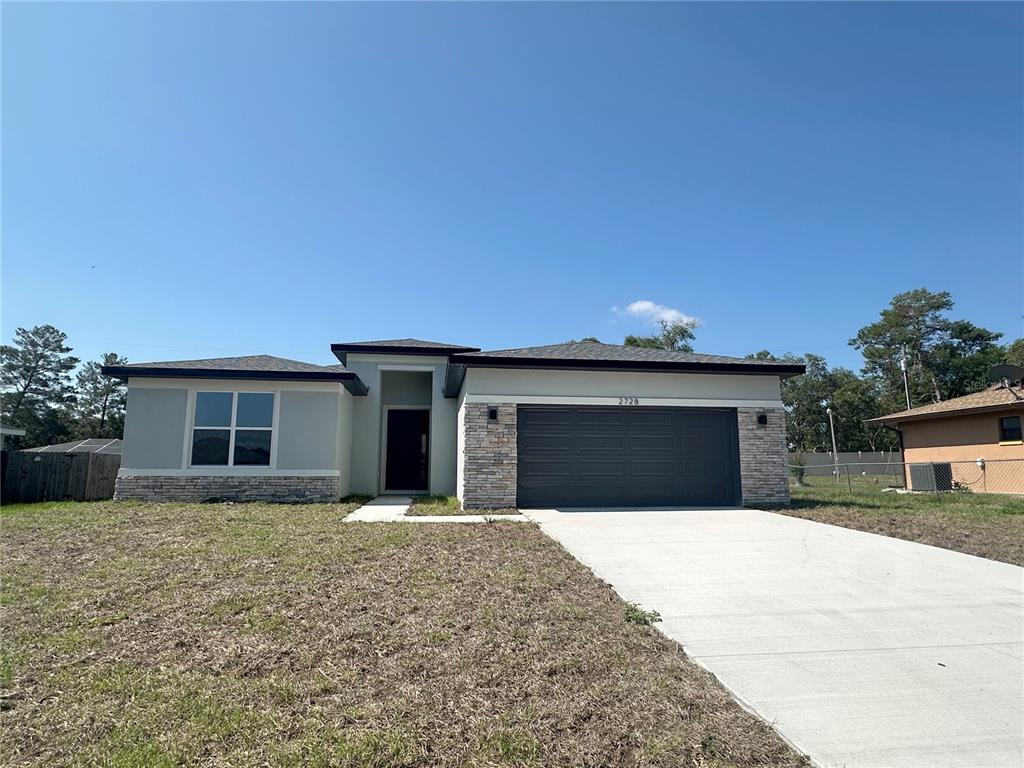 2728 Southwest 154th Place Road Ocala, FL 34473 - Photo 1 of 1 a front view of a house with yard and trees