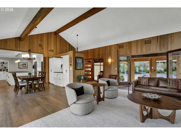 a living room with furniture a dining table and chairs with wooden floor
