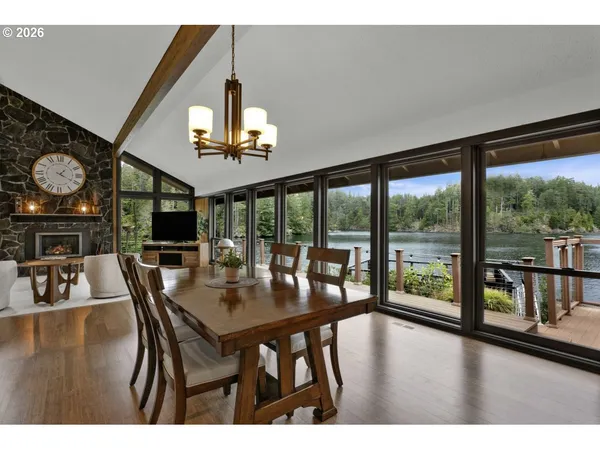 a dining room with wooden floor a chandelier a wooden table and chairs