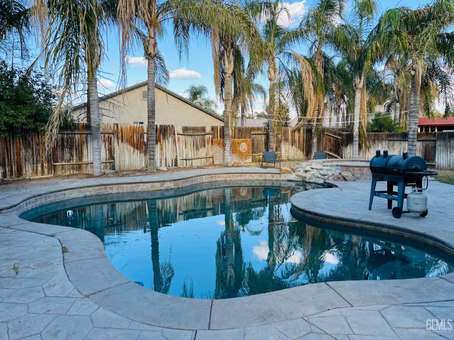 Undisclosed Address Bakersfield, CA 93313 - Photo 11 of 13 a view of a patio with table and chairs potted plants and palm trees