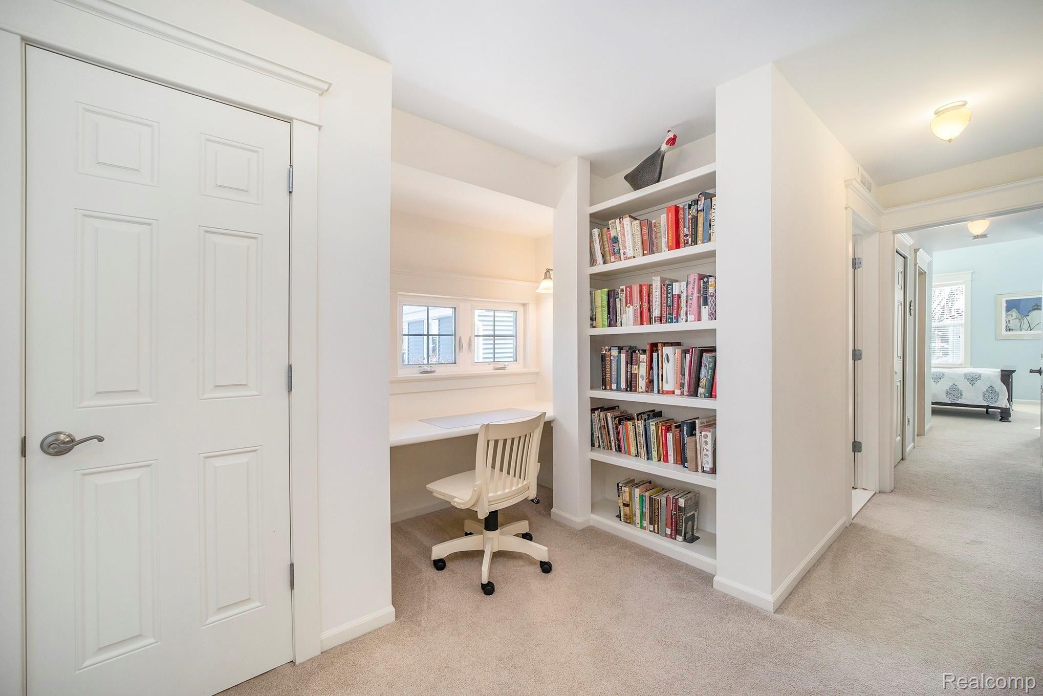 937 Ruffner Avenue Birmingham, MI 48009 - Photo 21 of 39 Custom built-in desk with bookshelves and sconce on the second floor provides a warm and functional workspace.