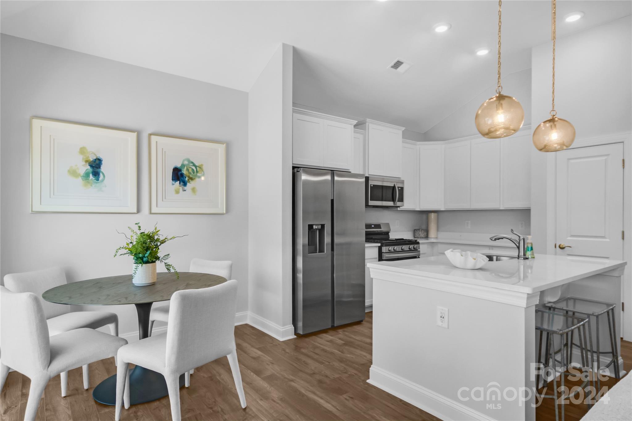 3159 Laurel Brook Drive Denver, NC 28037 - Photo 5 of 30 a kitchen with a refrigerator a sink a dining table and chairs