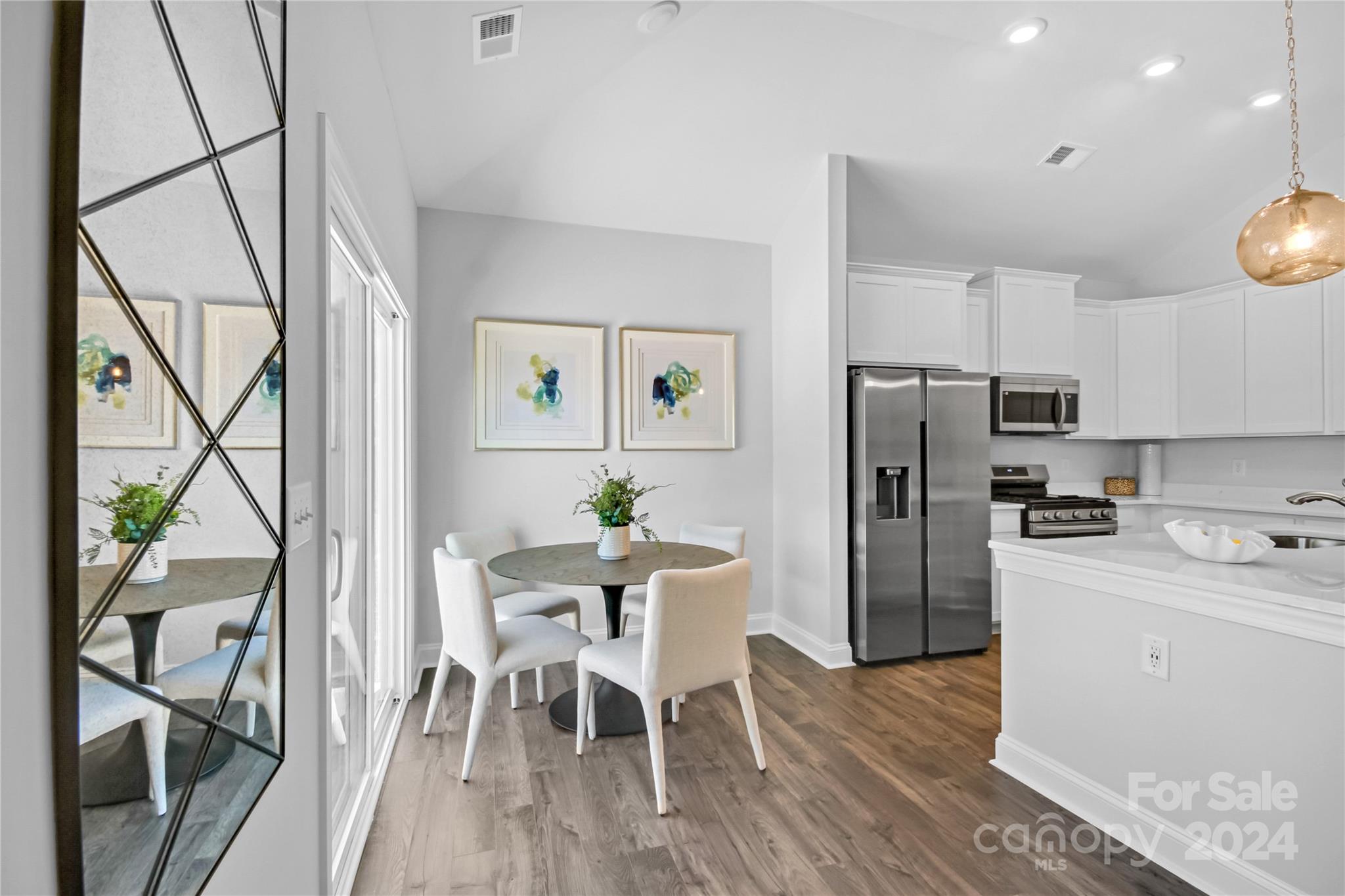 3159 Laurel Brook Drive Denver, NC 28037 - Photo 8 of 30 a kitchen with stainless steel appliances a refrigerator a stove a dining table and chairs with wooden floor