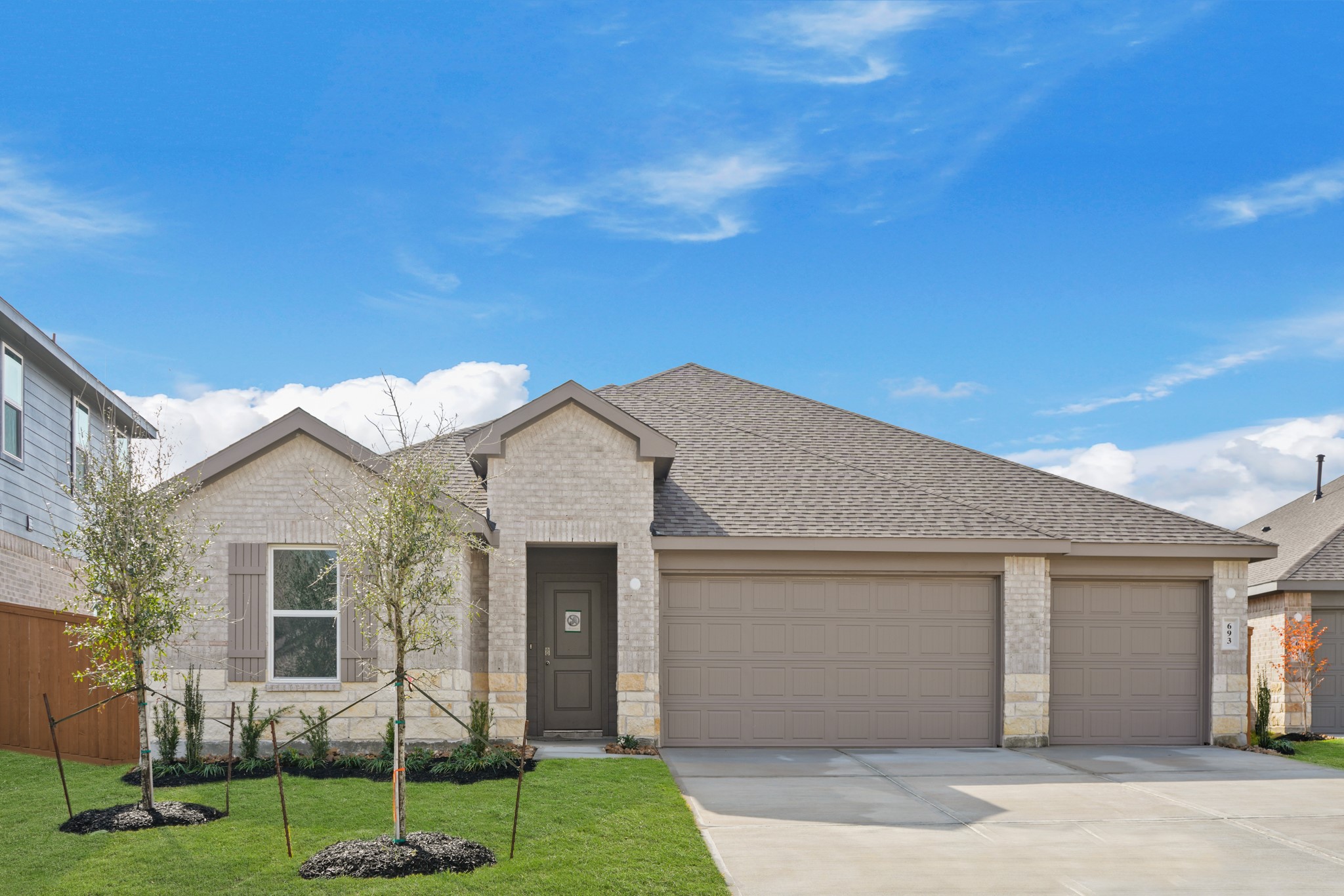 a front view of a house with a garden and yard
