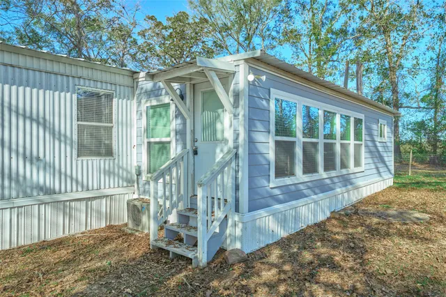 a view of wooden house with a yard