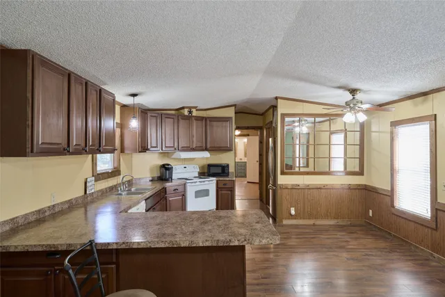 a kitchen with stainless steel appliances granite countertop a stove refrigerator and cabinets