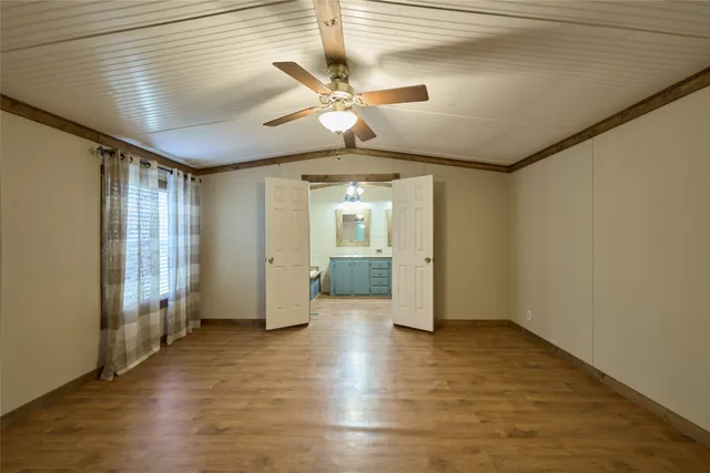 a view of a livingroom with wooden floor and a ceiling fan