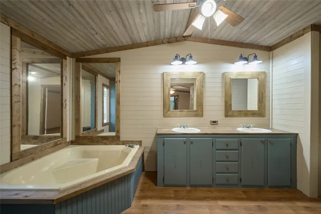 a bathroom with a tub sink and mirror