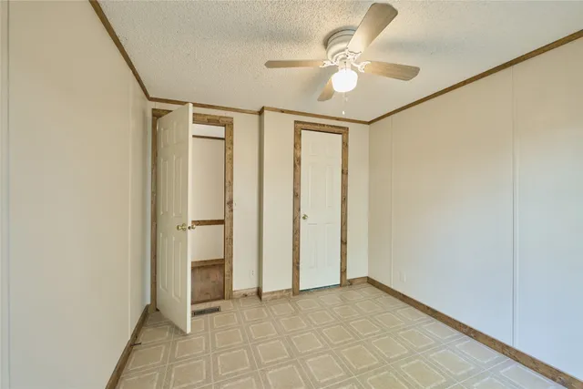 an empty room with fan and a ceiling fan