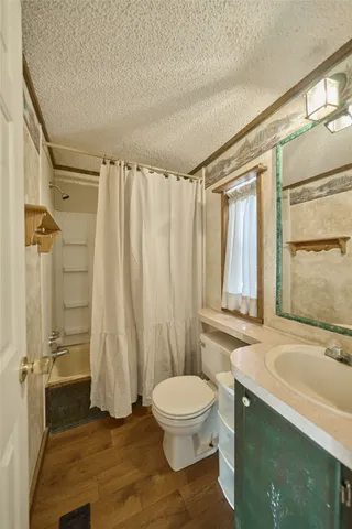 a bathroom with a granite countertop bathtub sink vanity mirror and toilet
