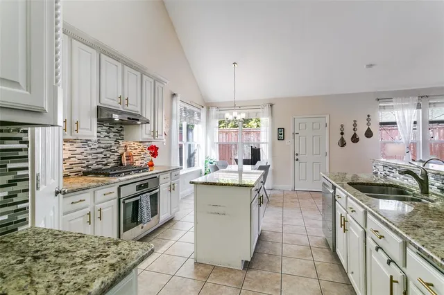a kitchen with a stove sink and cabinets