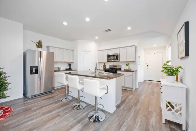 a living room with furniture kitchen view and a chandelier