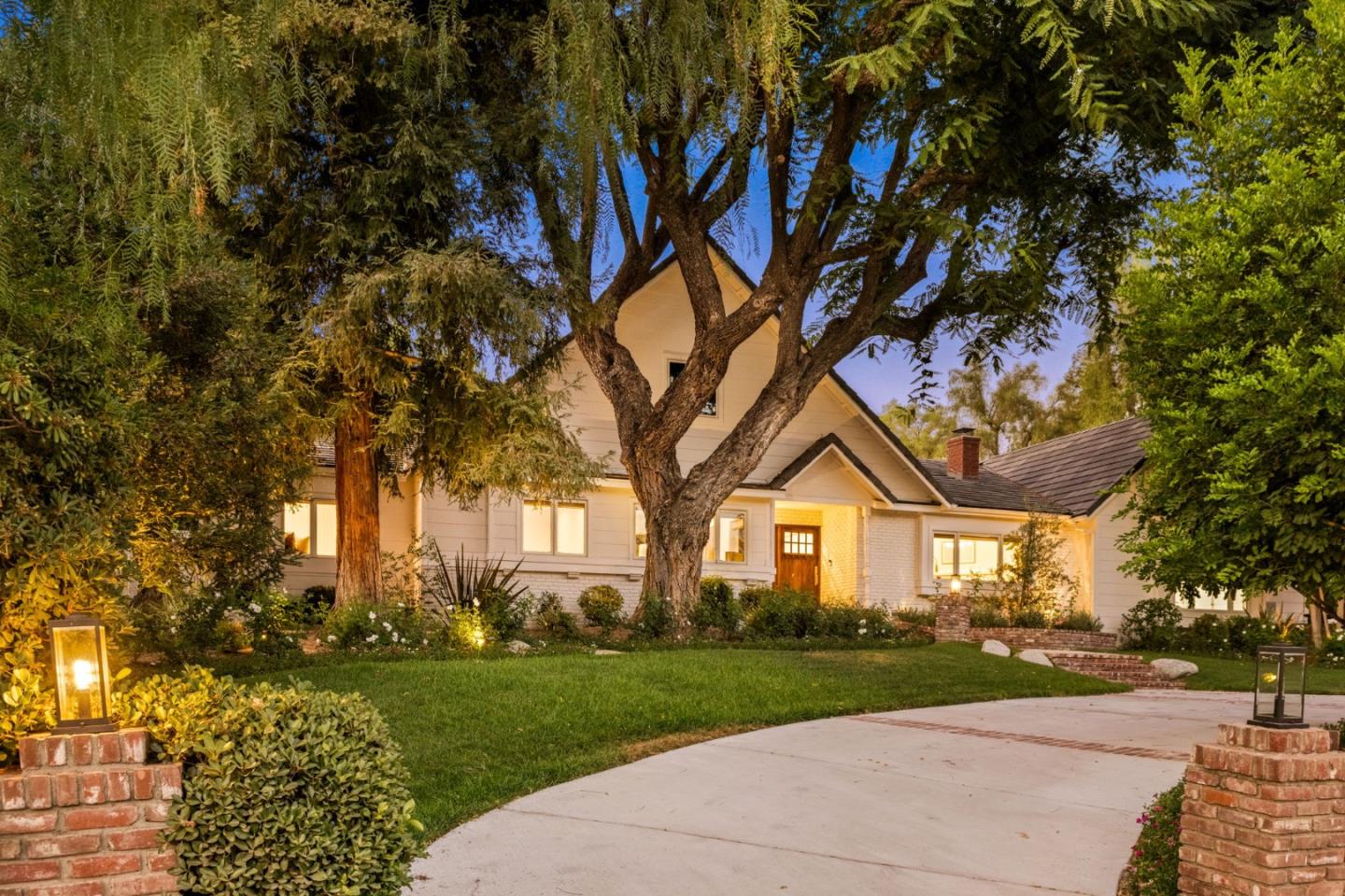 a front view of a house with a yard and tree s