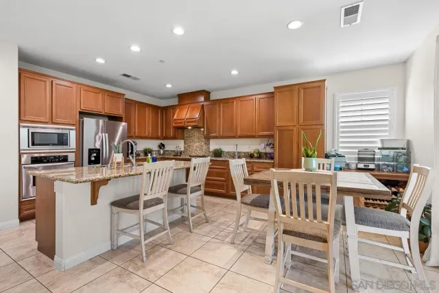 a kitchen with appliances a sink a counter top space and a center island