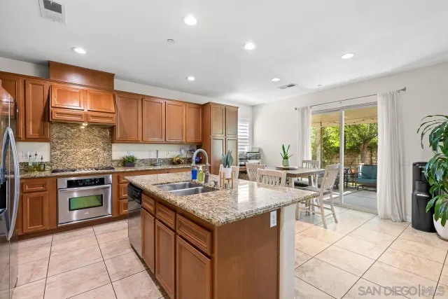 a kitchen with granite countertop a sink stove and cabinets