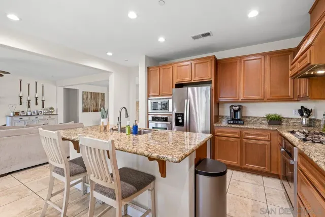 a kitchen with stainless steel appliances granite countertop a stove refrigerator sink and cabinets