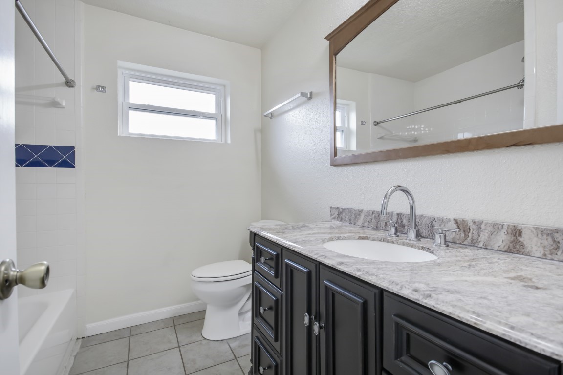 3203 Willie Way Spring, TX 77380 - Photo 14 of 31 a bathroom with a granite countertop sink a toilet and a mirror