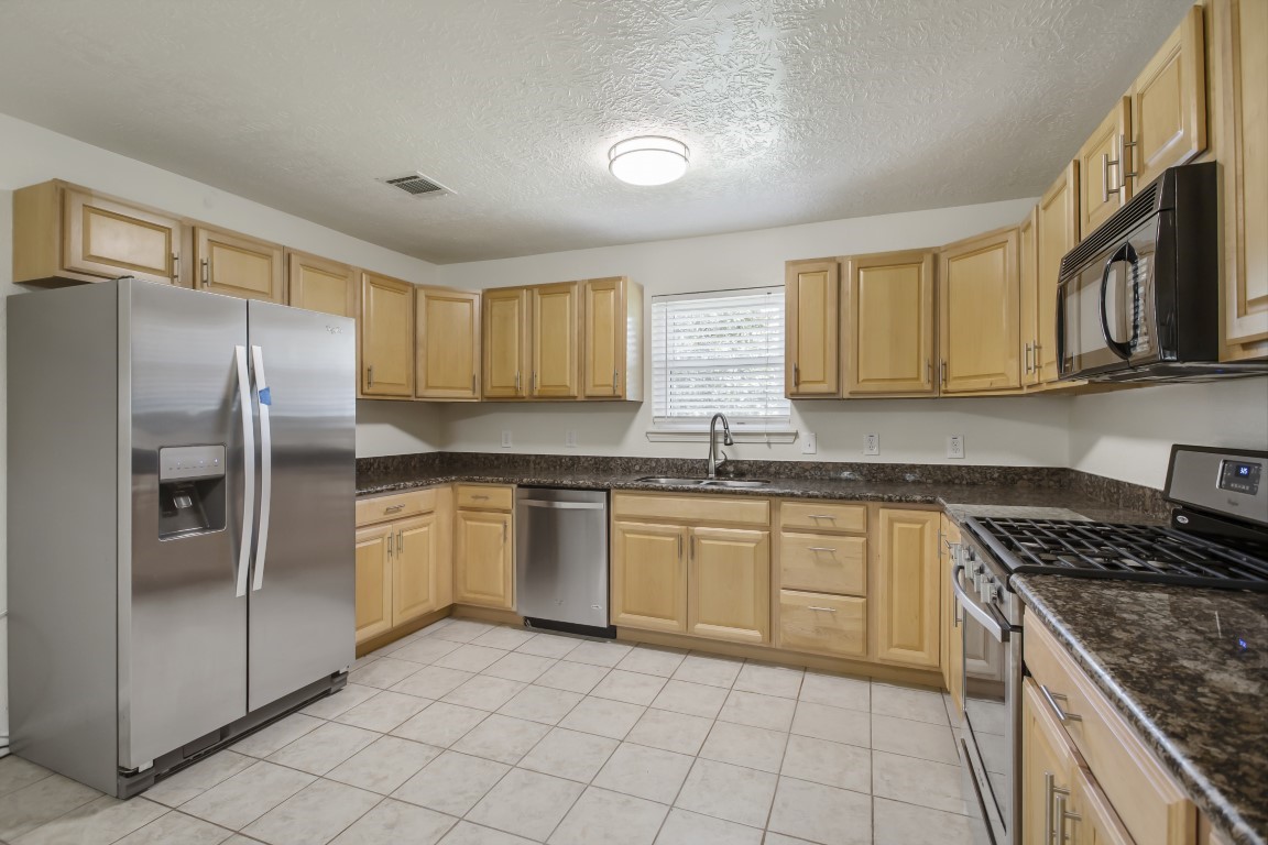 3203 Willie Way Spring, TX 77380 - Photo 6 of 31 a kitchen with stainless steel appliances granite countertop a stove top oven a sink and dishwasher
