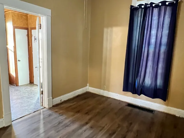 an empty room with wooden floor and door