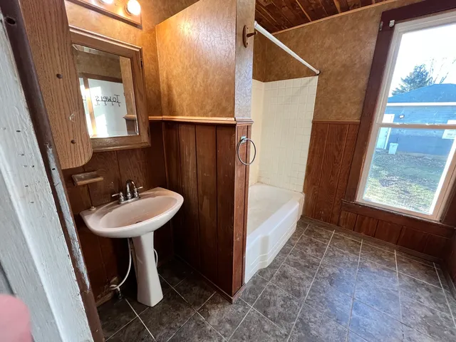 a bathroom with a tub a sink and a shower
