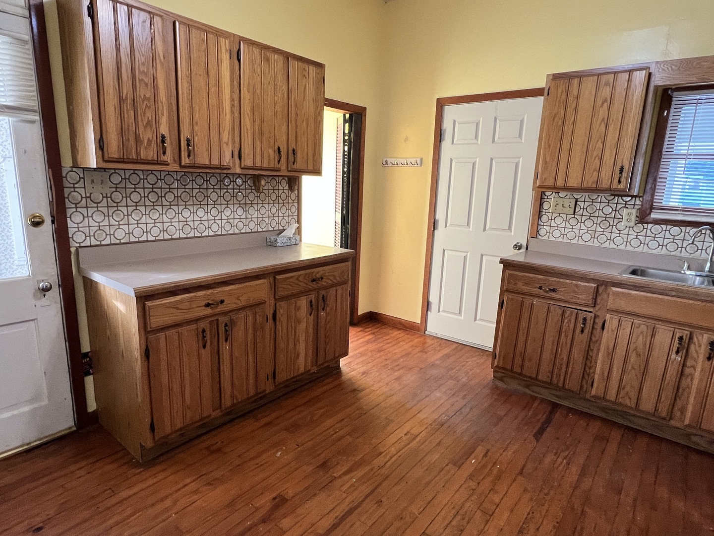 501 North Elm Street Clinton, IL 61727 - Photo 29 of 37 a kitchen with wooden floors wooden cabinets and sink