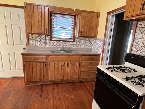 an empty room with wooden floor and cabinet
