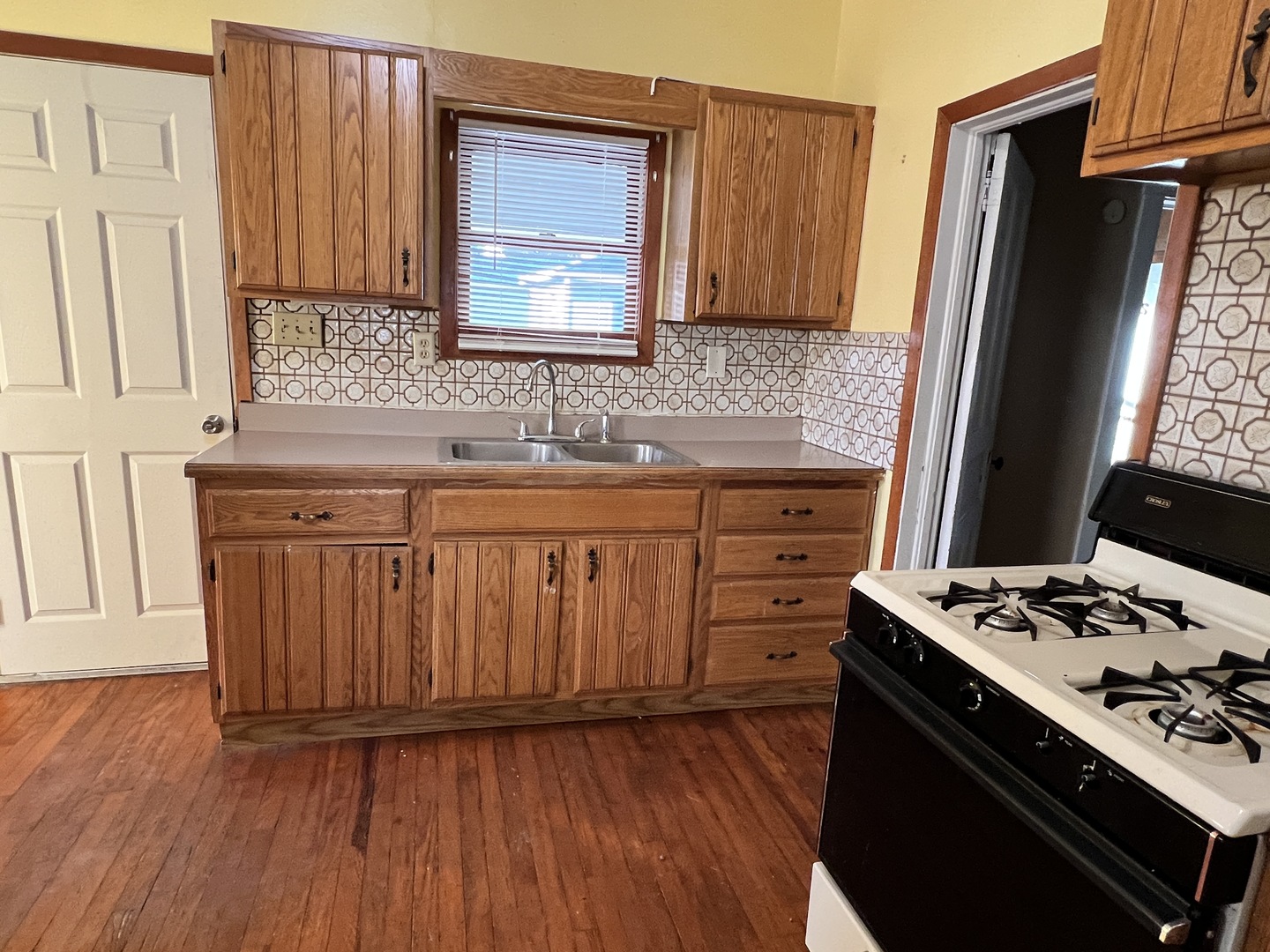 501 North Elm Street Clinton, IL 61727 - Photo 31 of 37 a kitchen with granite countertop a sink stove and wooden floor