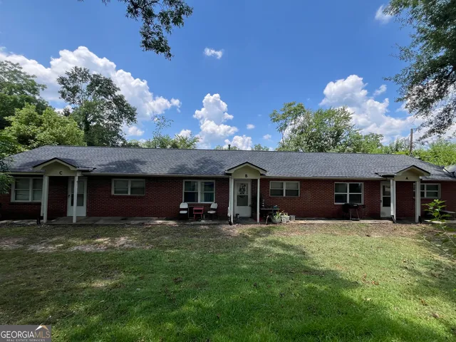 a front view of a house with yard and green space