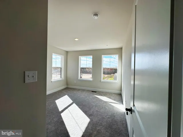 an empty room with windows and closet