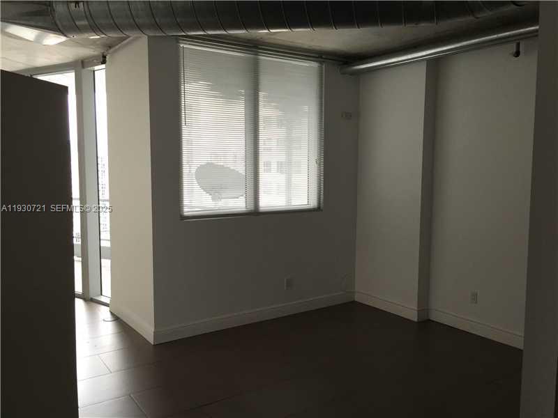690 Southwest 1st Court, Unit 1727 Miami, FL 33130 - Photo 10 of 15 a view of a small space with wooden floor and a window