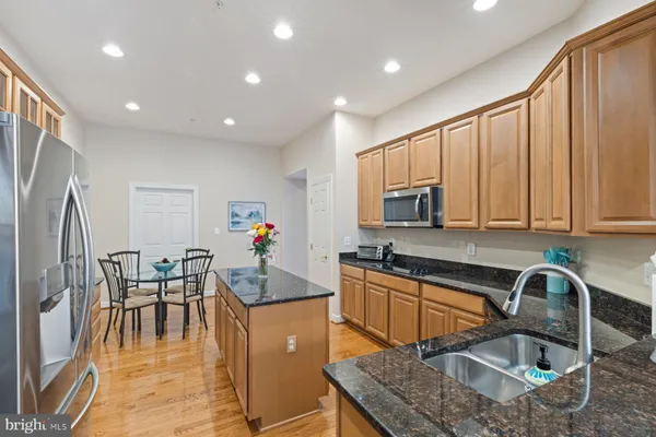 a kitchen with stainless steel appliances granite countertop sink stove refrigerator and cabinets
