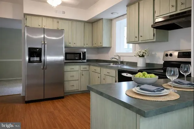 a kitchen with stainless steel appliances kitchen island granite countertop a refrigerator sink and stove
