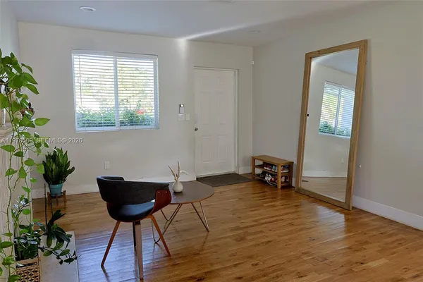 a room with furniture a potted plant and wooden floor