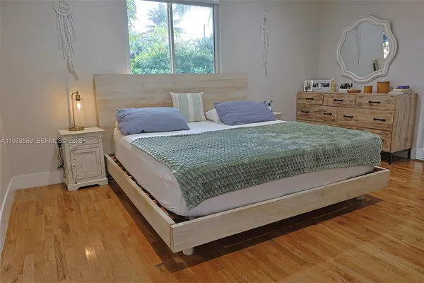 a bed sitting in a bedroom next to a window