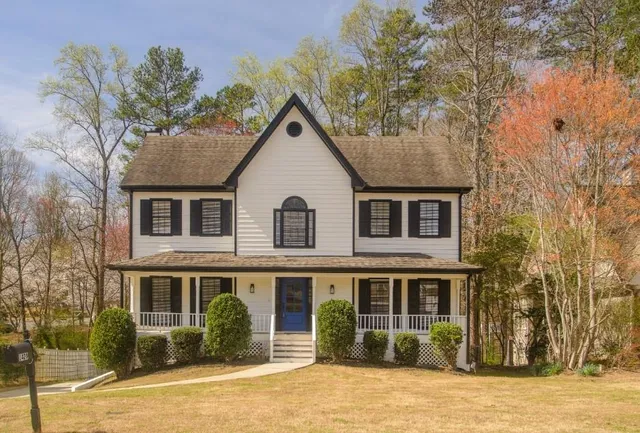 a view of a yard in front of a brick house with large windows