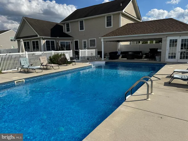 a front view of a house with swimming pool having outdoor seating