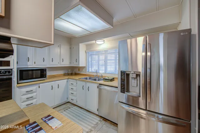 a kitchen with stainless steel appliances granite countertop a refrigerator and a sink